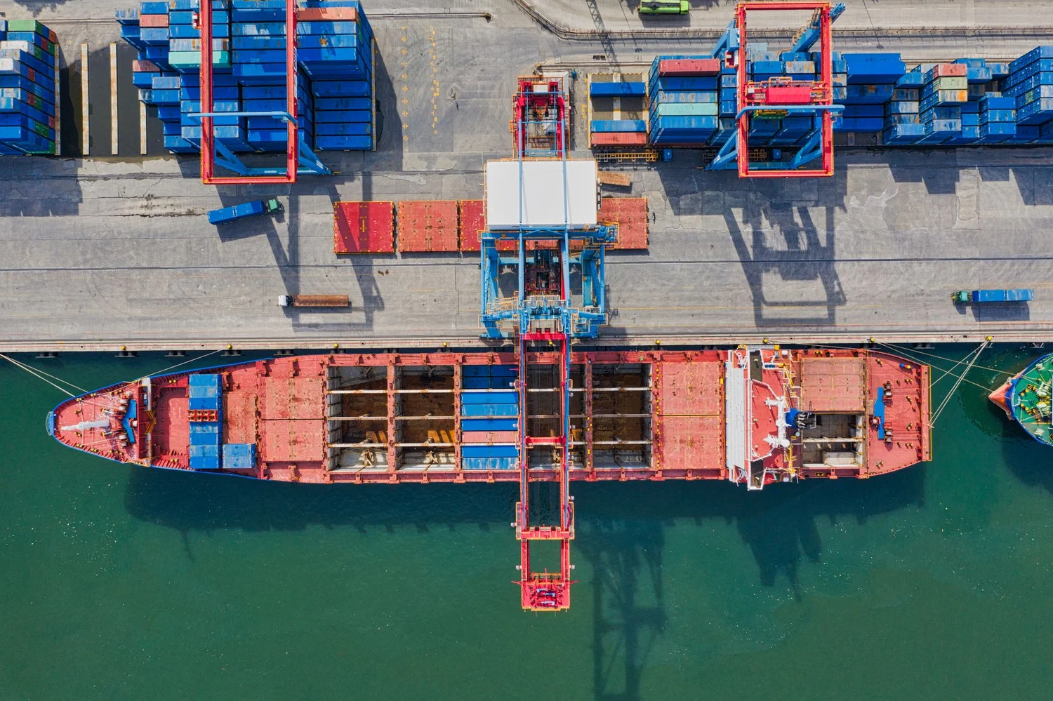 Customs officer reviewing importer paperwork at a shipping port with cargo containers