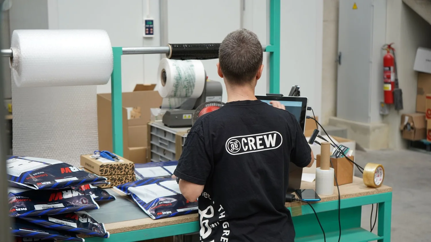 Amazon seller checking Seller Central notifications and shipping return labels at a desk